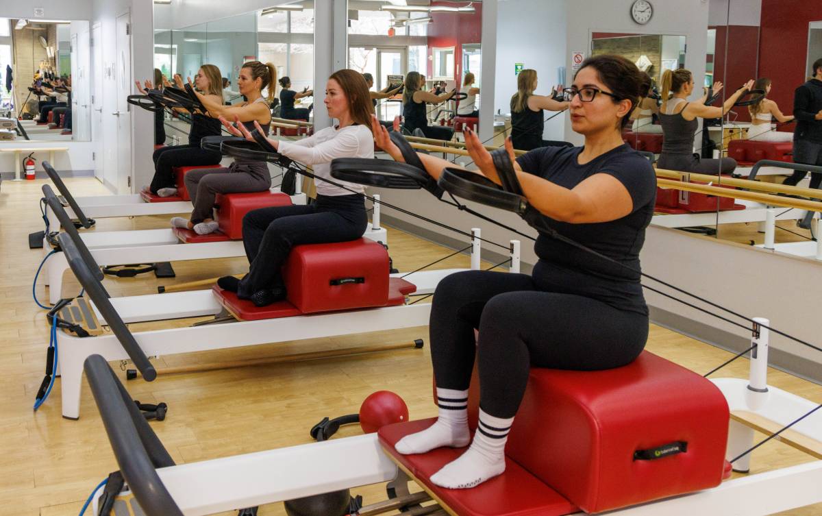 Leg squat exercises on the Pilates Power Gym reformer
