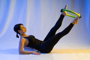 athletic woman doing pilates toning exercises for abs with a circle