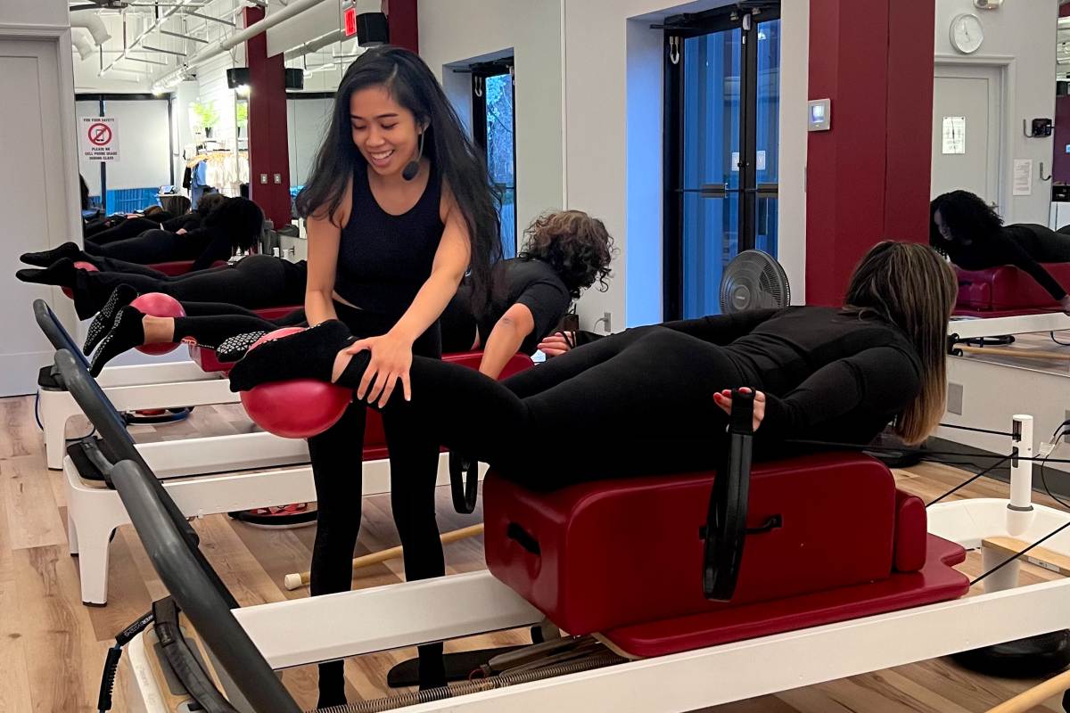 DC Reformer Pilates instructor correcting position