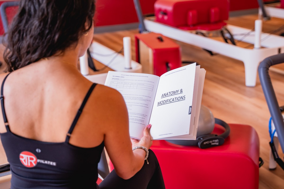 Northern Virginia pilates instructor reading pilates coursebook