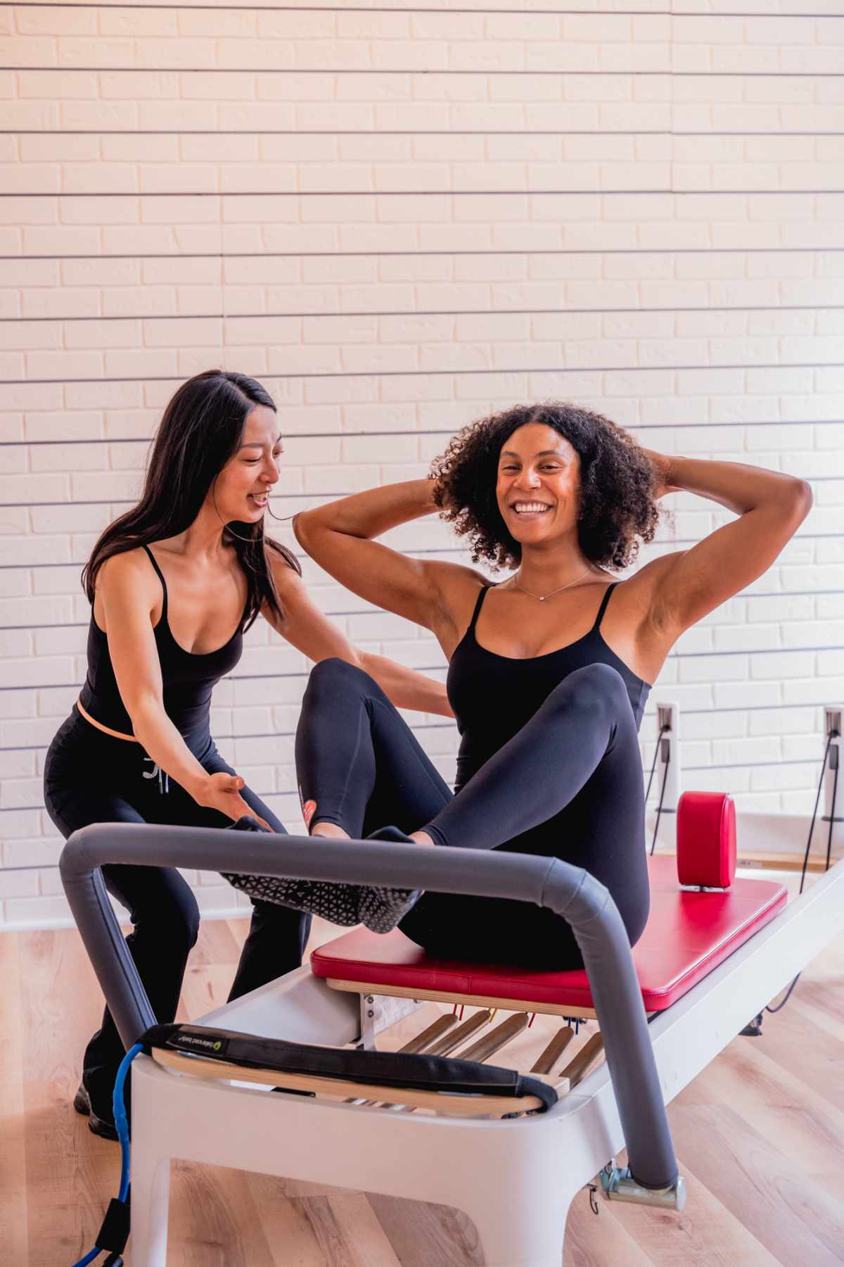 Reformer pilates instructor helping with form