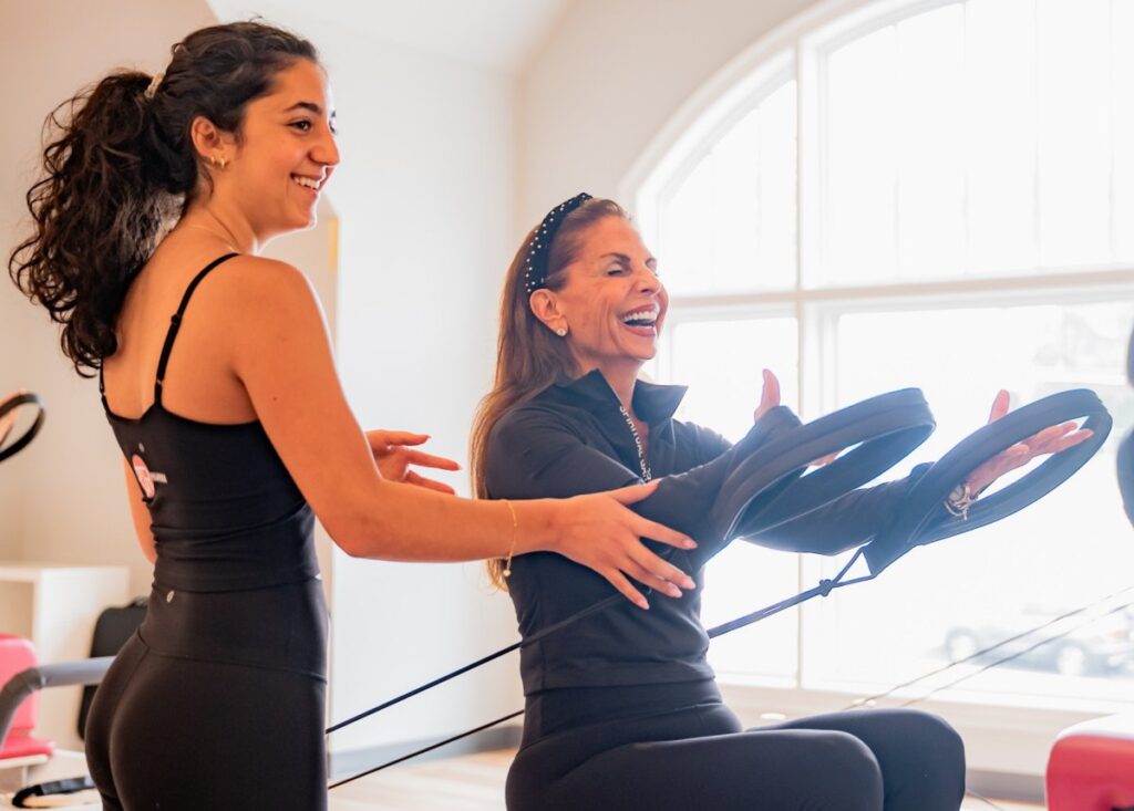 beginners pilates class instructor laughing with client