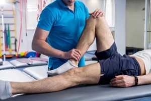 physiotherapist working with young male patient in the rehabilitation center