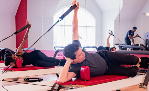 senior man doing side lying arm on reformer