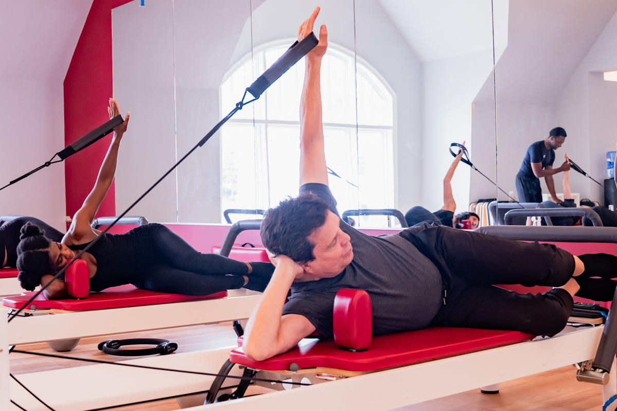 senior man doing side lying arm on reformer