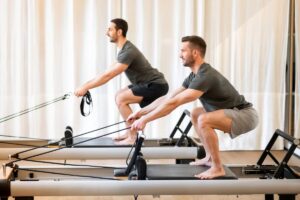 Washington DC men doing reformer pilates core exercises