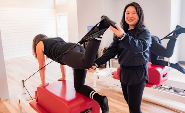 Christine, Chevy Chase, VA pilates instructor, holding foot in strap on pilates reformer