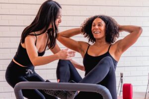 Reformer pilates instructor correcting core