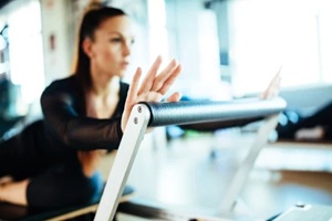 young females doing reformer exercises on pilates machines