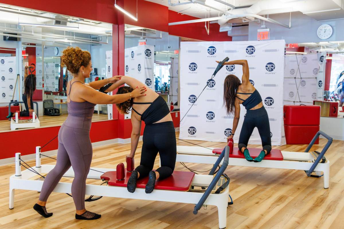 Reformer Pilates class does side arm correction