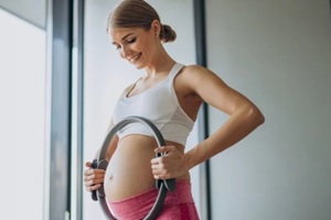 pregnant woman practicing yoga at home