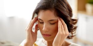 people , health and stress concept - unhappy woman suffering from head ache at home