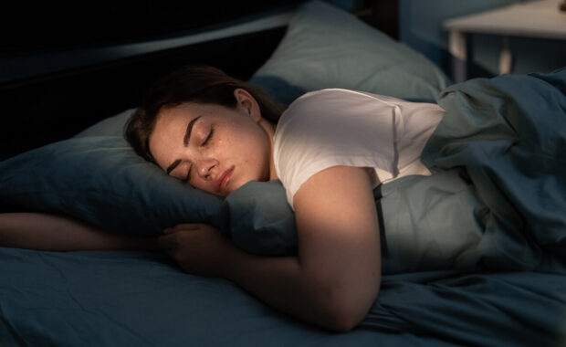 young female sleeping peacefully in her bedroom at night after reformer pilates class