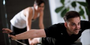 men and women engaging in a focused workout on reformer pilates machines in a modern fitness studio