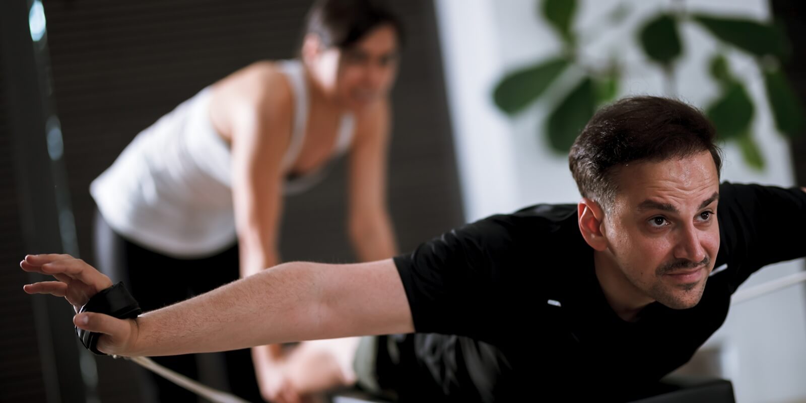 men and women engaging in a focused workout on reformer pilates machines in a modern fitness studio